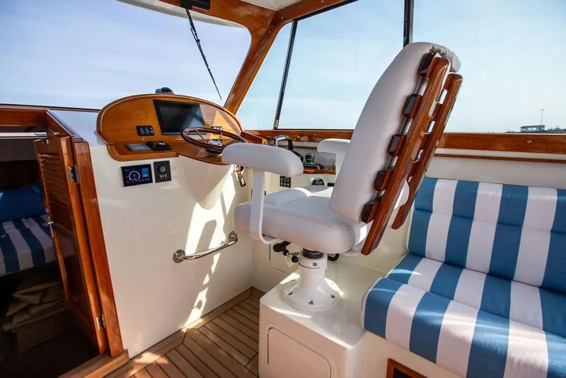 Slide: The Image of Interior of a 2022 Hinckley 35 boat with helm and striped seating. - 1