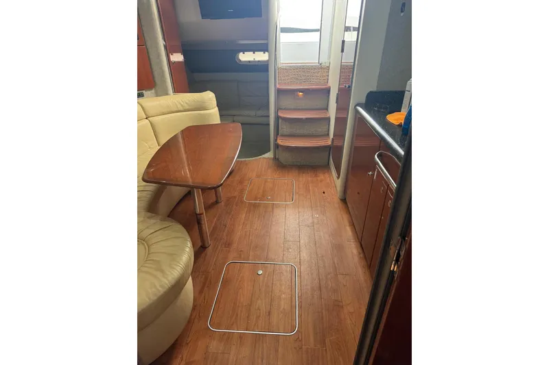 Slide: The Image of 2008 Formula 37 Performance Cruiser interior with wood flooring, beige seating, and compact kitchen area. - 19