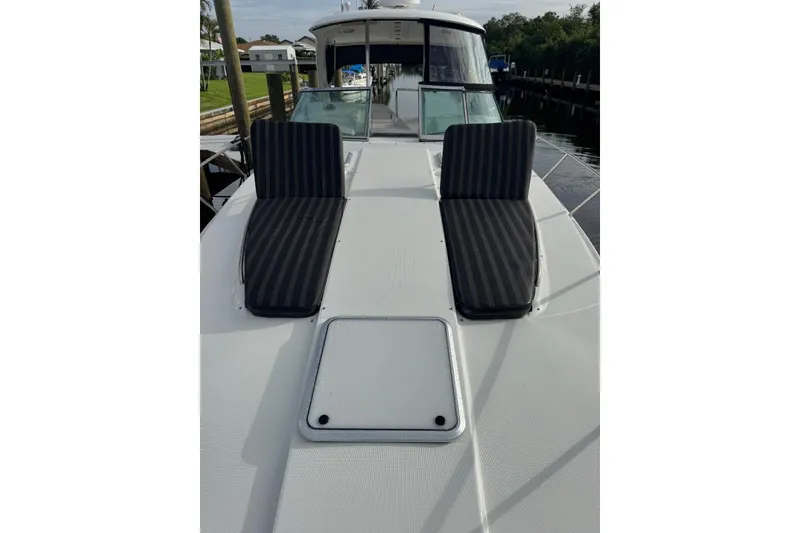 Slide: The Image of 2008 Formula 37 Performance Cruiser with striped deck cushions, docked near waterfront homes. - 3