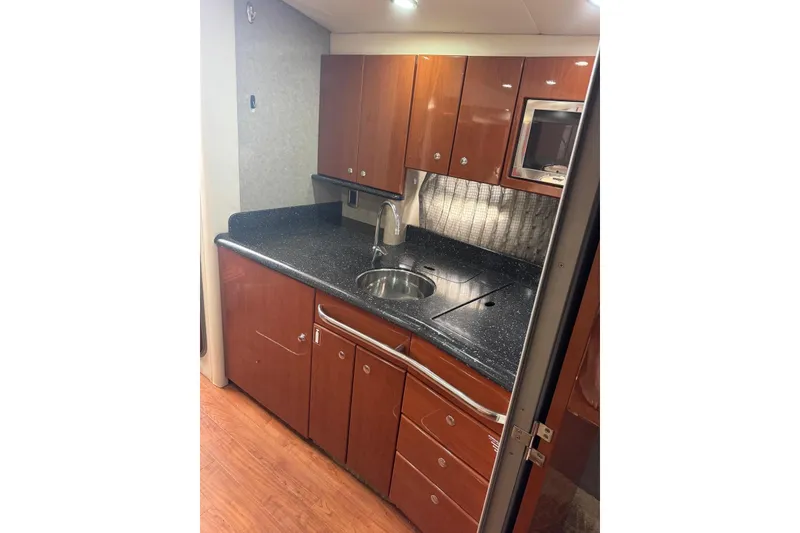Slide: The Image of 2008 Formula 37 Performance Cruiser kitchen with wood cabinets and black countertop. - 32