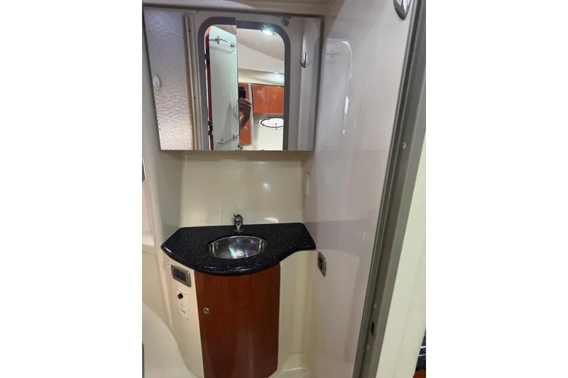 Slide: The Image of 2008 Formula 37 Performance Cruiser bathroom with sink, mirror, and wooden cabinetry. - 38
