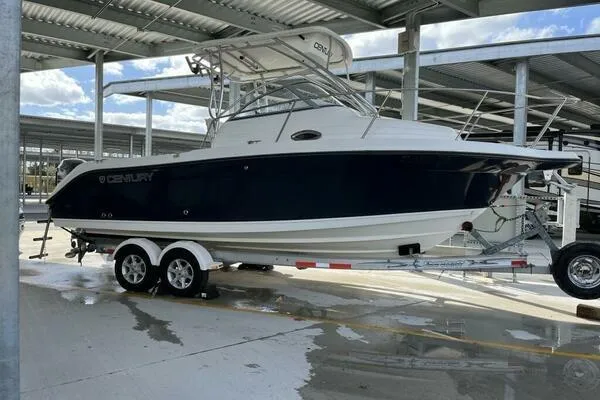 The Image of 2006 Century 2400 Walk-Around boat on trailer in covered storage area. - 1