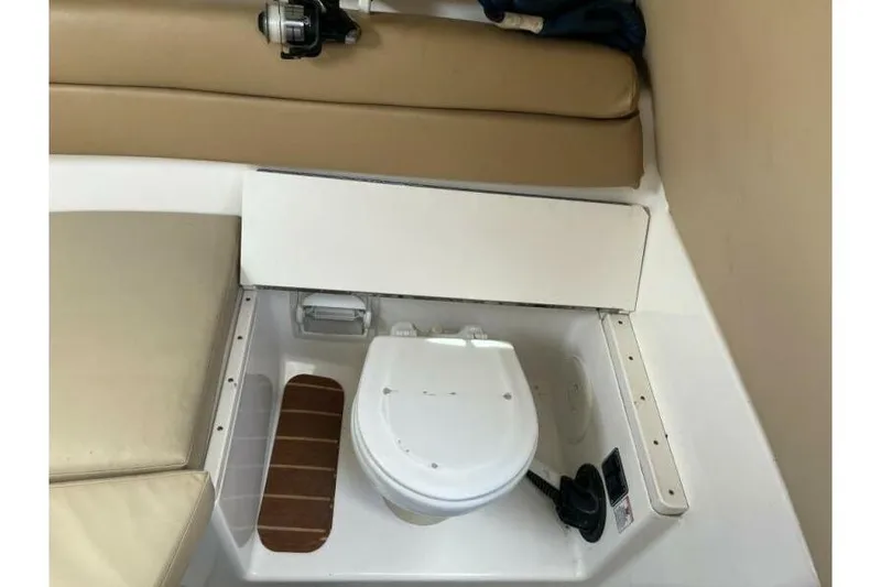 Slide: The Image of Interior of a 2006 Century 2400 Walk-Around boat featuring a compact marine toilet. - 13