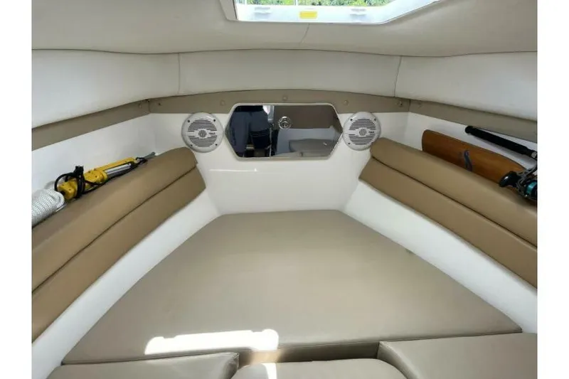 Slide: The Image of Interior cabin of 2006 Century 2400 Walk-Around boat with beige seating and speakers. - 14