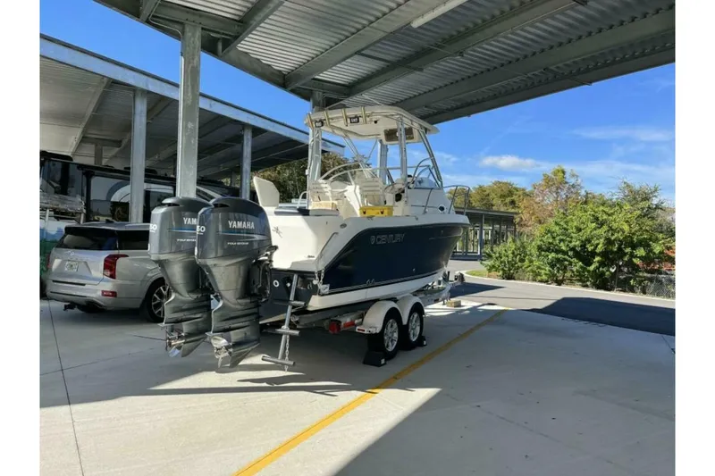 Slide: The Image of 2006 Century 2400 Walk-Around boat with Yamaha engines, parked under a metal canopy. - 3