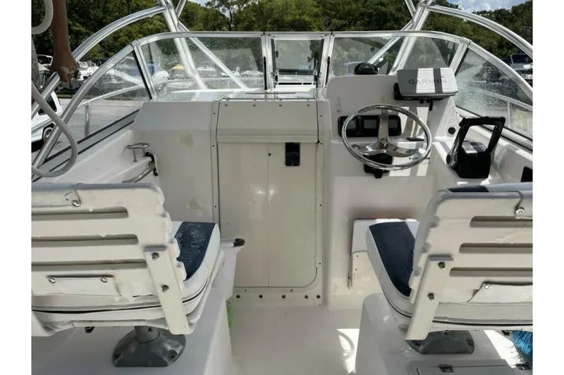Slide: The Image of 2006 Century 2400 Walk-Around boat interior with steering wheel and seating. - 5