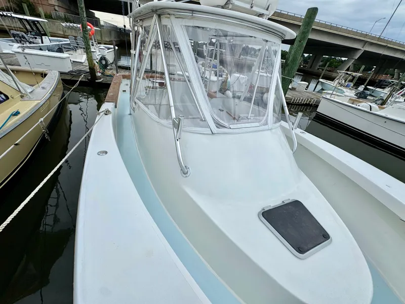 Slide: The Image of A 1992 L&H 33 boat docked. It features an enclosed helm area. - 15