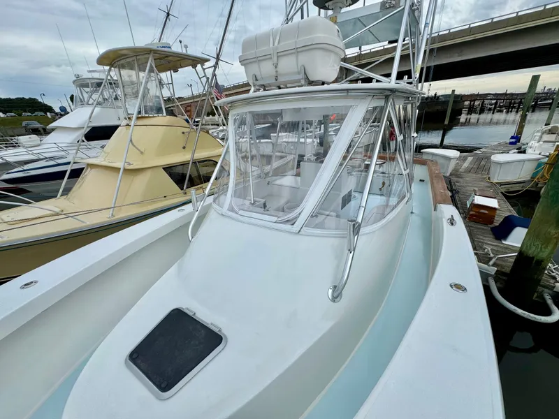 Slide: The Image of A 1992 L&H 33 boat docked. It features a raised helm and clear windshield. - 16