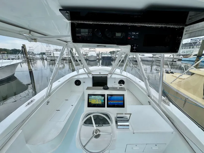 Slide: The Image of The cockpit of a 1992 L&H 33 with modern electronics and a clear view of the marina. - 17