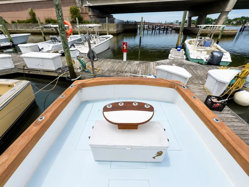 Slide: The Image of The boat is docked, featuring a wooden table and a cooler on board. - 32