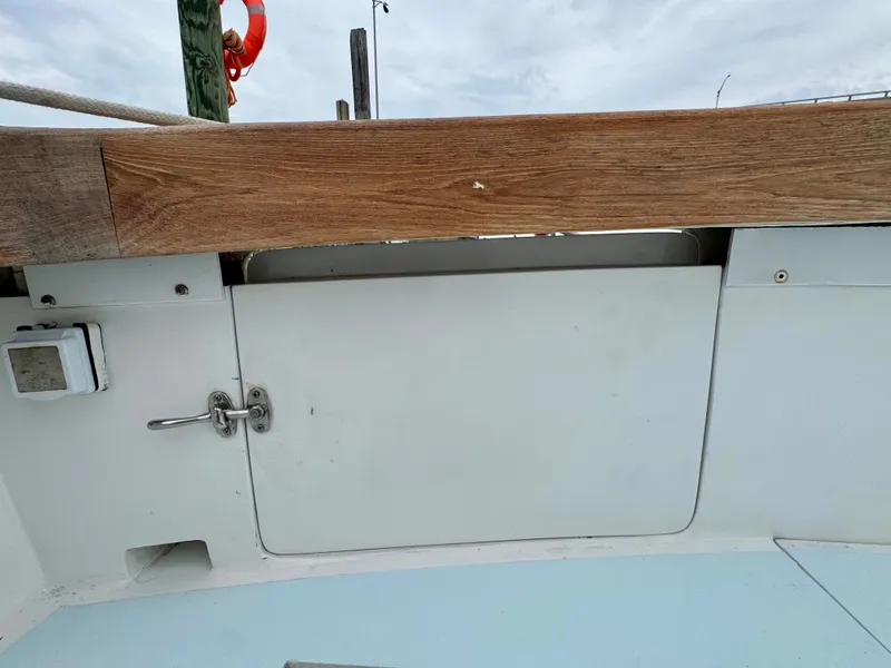 Slide: The Image of A section of the deck of a 1992 L&H 33 boat with wood elements and a white door. - 26