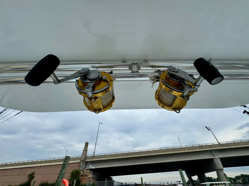 Slide: The Image of Two fishing reels are mounted on a boat's ceiling, with a bridge in the background. - 33