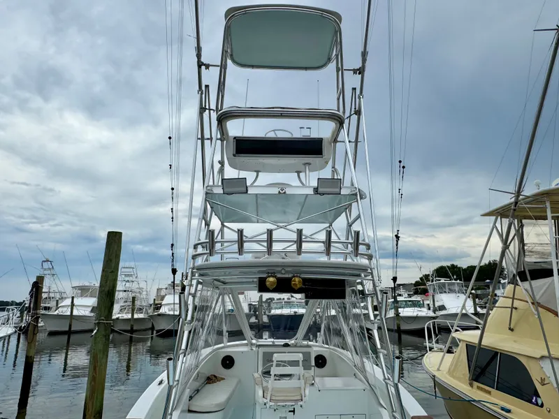 Slide: The Image of A 1992 L&H 33 boat with a tall helm station, docked in a marina. - 34
