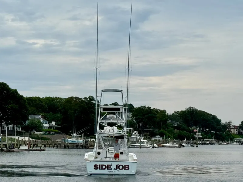 Slide: The Image of A 1992 L&H 33 boat named "Side Job" is cruising on calm waters. - 5