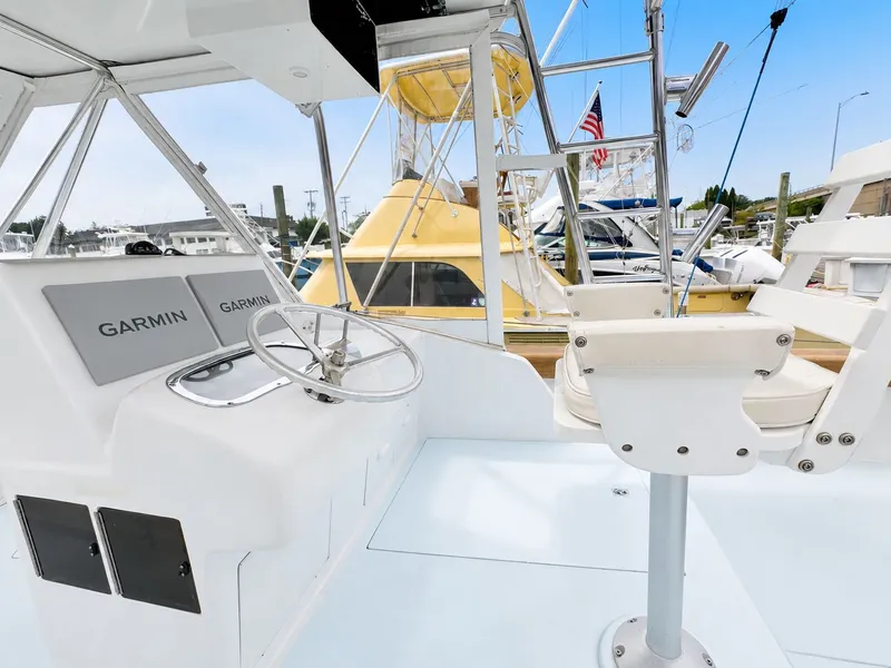 Slide: The Image of The image shows the helm of a 1992 L&H 33 boat with a Garmin navigation system. - 24