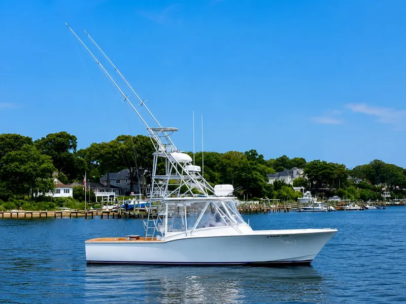 Slide: The Image of A white fishing boat with a tall tower on calm water, surrounded by green trees and houses. - 6