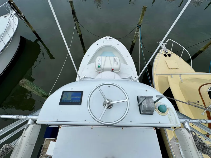Slide: The Image of A 1992 L&H 33 boat docked, featuring a helm station and navigation screen. - 7