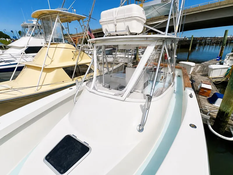 Slide: The Image of A 1992 L&H 33 boat docked, featuring a white deck and cabin. - 16