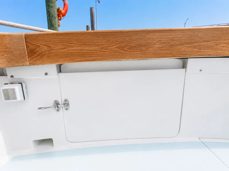 Slide: The Image of Close-up of a white boat deck with wood trim and a small latch. - 26