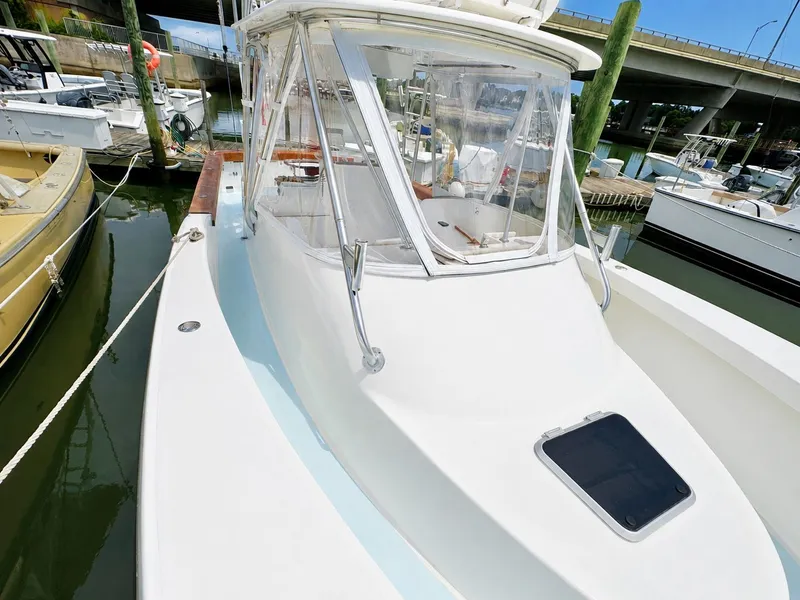 Slide: The Image of A 1992 L&H 33 boat docked, featuring an enclosed helm area. - 15