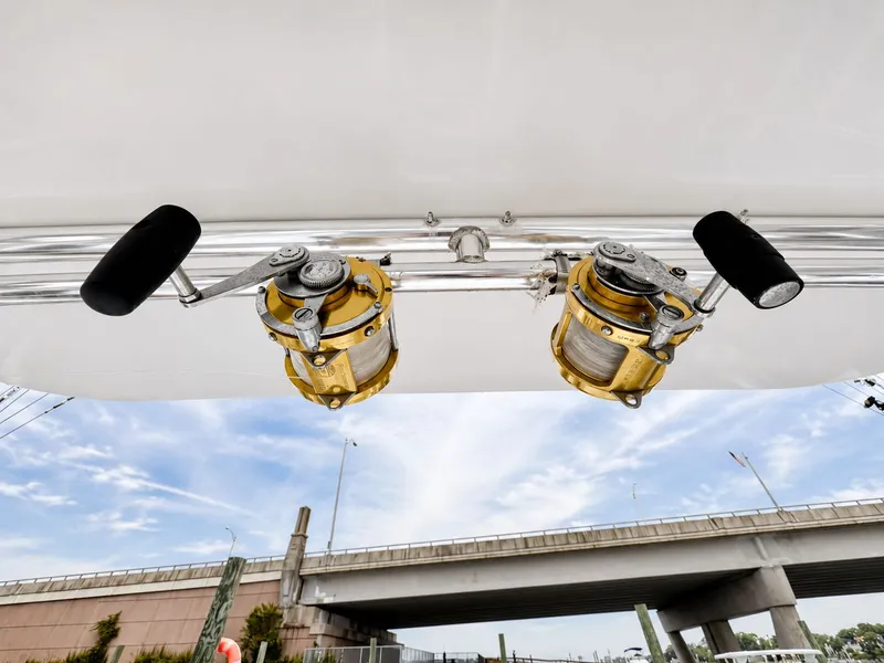Slide: The Image of Two gold fishing reels are mounted on a bracket under a white canopy. - 33