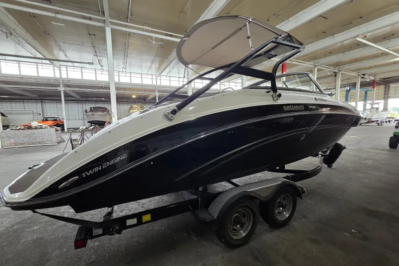 The Image of 2013 Yamaha 242 Limited S boat on trailer in indoor storage facility. - 1