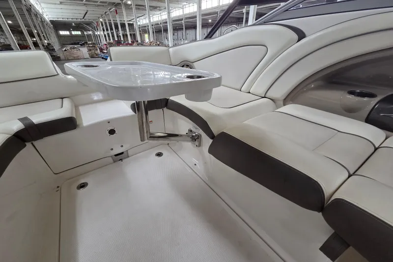 Slide: The Image of Interior of 2013 Yamaha 242 Limited S boat with seating and table in a warehouse. - 16
