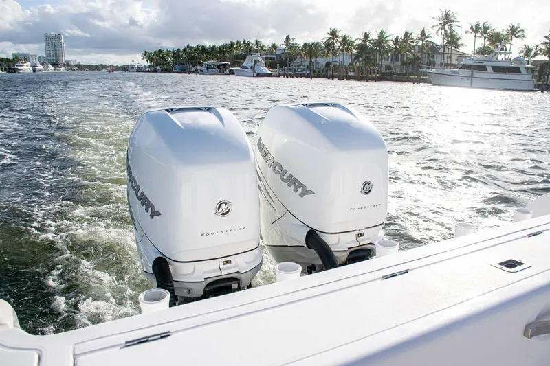Slide: The Image of Twin Mercury outboard engines on a 2021 Intrepid boat, cruising through a scenic waterway. - 20