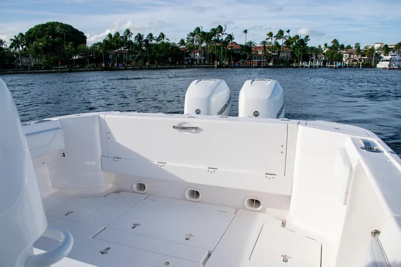 Slide: The Image of 2021 Intrepid boat with dual engines on a calm waterway, surrounded by lush greenery. - 18
