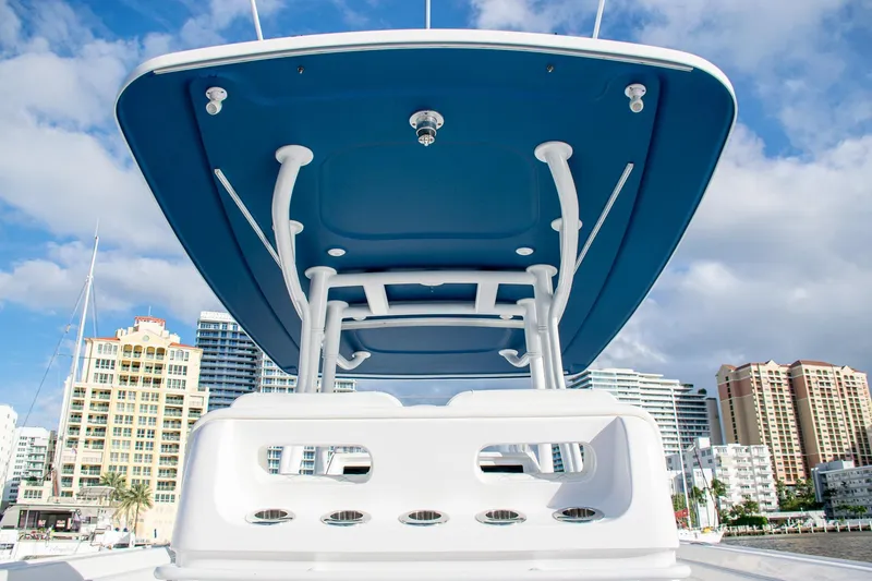 Slide: The Image of Intrepid 2021 boat with blue canopy, city skyline in background, under a cloudy sky. - 31