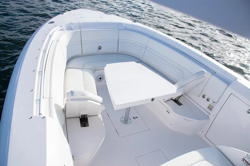 Slide: The Image of Luxurious 2021 Intrepid boat interior with white seating and table on calm water. - 12