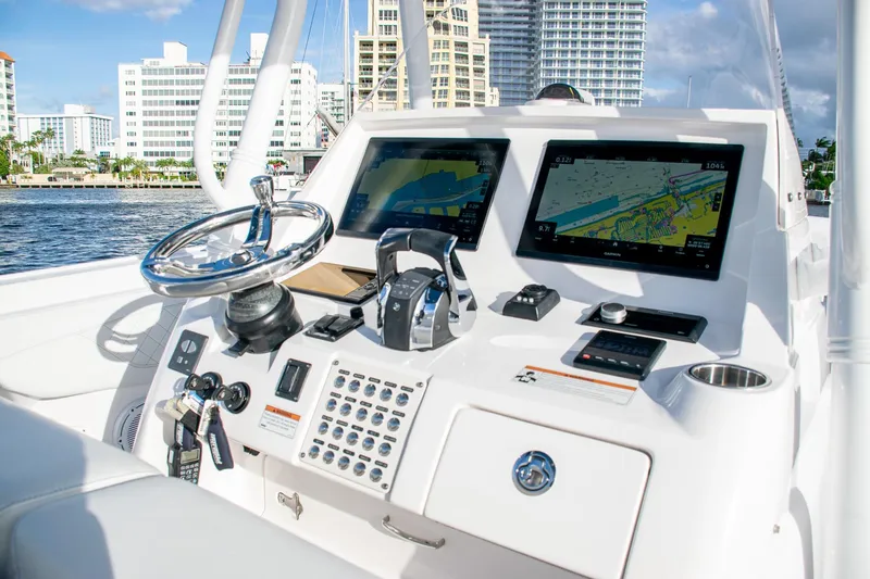 Slide: The Image of Intrepid 2021 boat dashboard with dual navigation screens and steering wheel, docked near cityscape. - 27