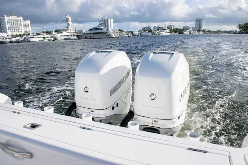Slide: The Image of Twin Mercury outboard engines on a 2021 Intrepid boat, cruising in a marina. - 21