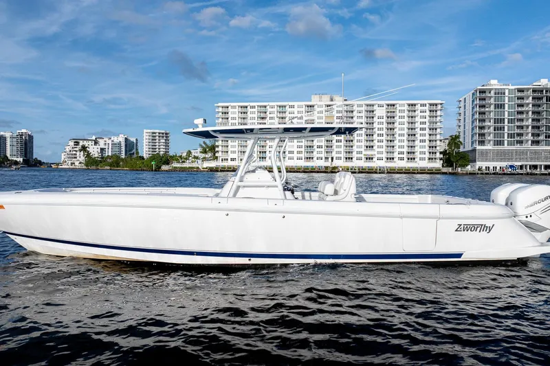 Slide: The Image of 2021 Intrepid boat on water with cityscape background, featuring sleek design and twin engines. - 3