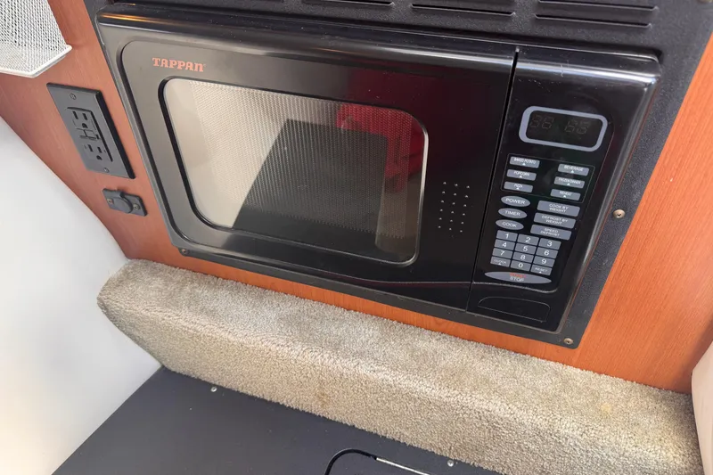 Slide: The Image of Tappan microwave in 2008 Crownline 320 LS boat interior, featuring control panel and power outlet. - 18