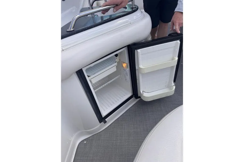 Slide: The Image of Open mini fridge on 2008 Crownline 320 LS boat, showcasing interior storage space. - 22