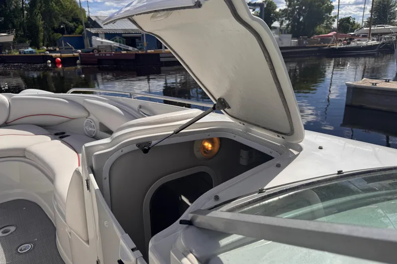 Slide: The Image of Open hatch on 2008 Crownline 320 LS boat, revealing interior storage space by the dock. - 25
