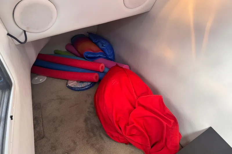 Slide: The Image of Storage area in a 2008 Crownline 320 LS boat with pool noodles and life jackets. - 26
