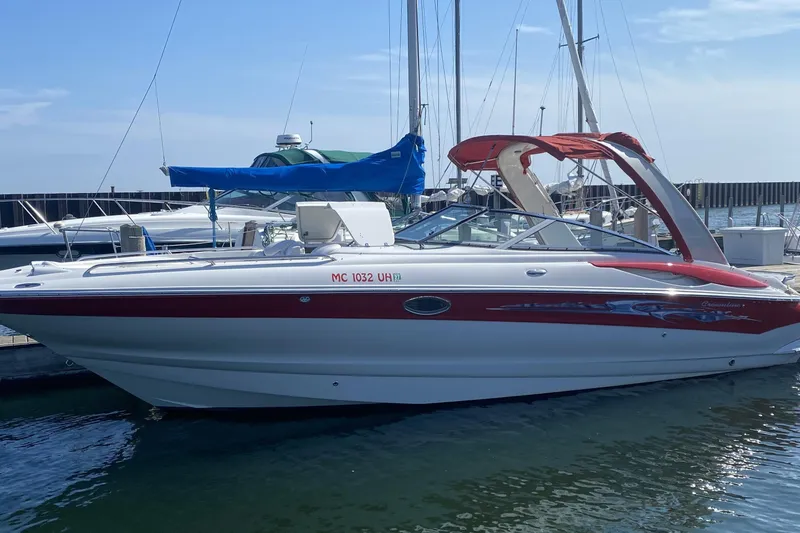 Slide: The Image of 2008 Crownline 320 LS boat docked at marina, featuring red and white design. - 4