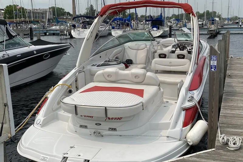 Slide: The Image of 2008 Crownline 320 LS boat docked at marina, featuring red and white seating. - 6