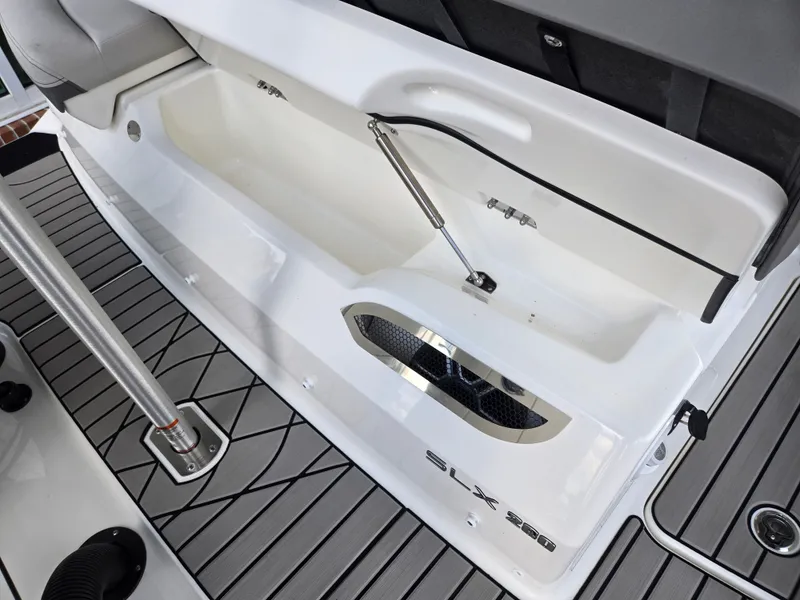 Slide: The Image of The image shows the storage area of a 2027 Sea Ray SLX 280 Outboard boat with gray flooring. - 4