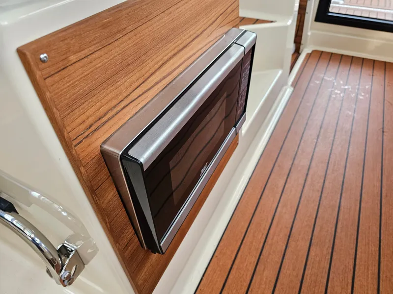 Slide: The Image of A modern microwave is integrated into a wooden wall on a boat. - 26