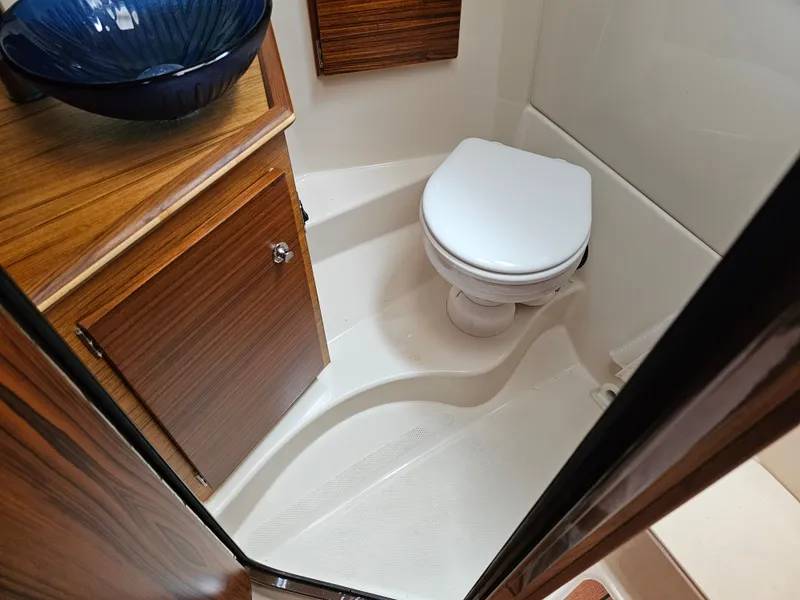 Slide: The Image of The image shows a modern boat bathroom with a toilet and a sink. - 24