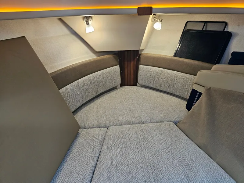 Slide: The Image of The 2025 Ranger Tugs R-27 cabin features a cozy seating area with upholstery and lighting. - 19