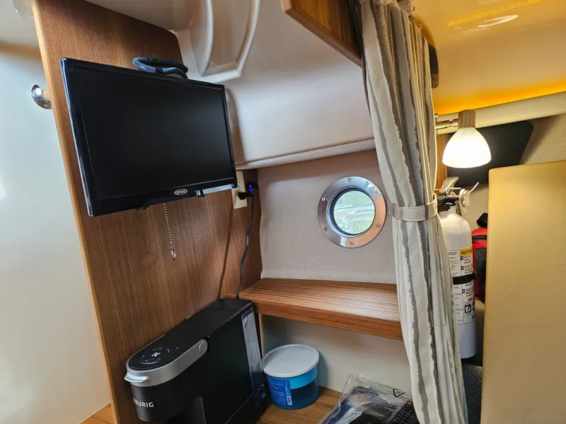 Slide: The Image of Interior of a Ranger Tugs R-27 with a TV, porthole, and coffee maker. - 20
