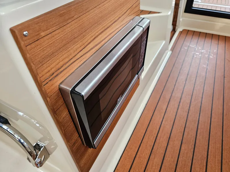 Slide: The Image of A modern microwave is integrated into a wooden wall on a boat. - 26