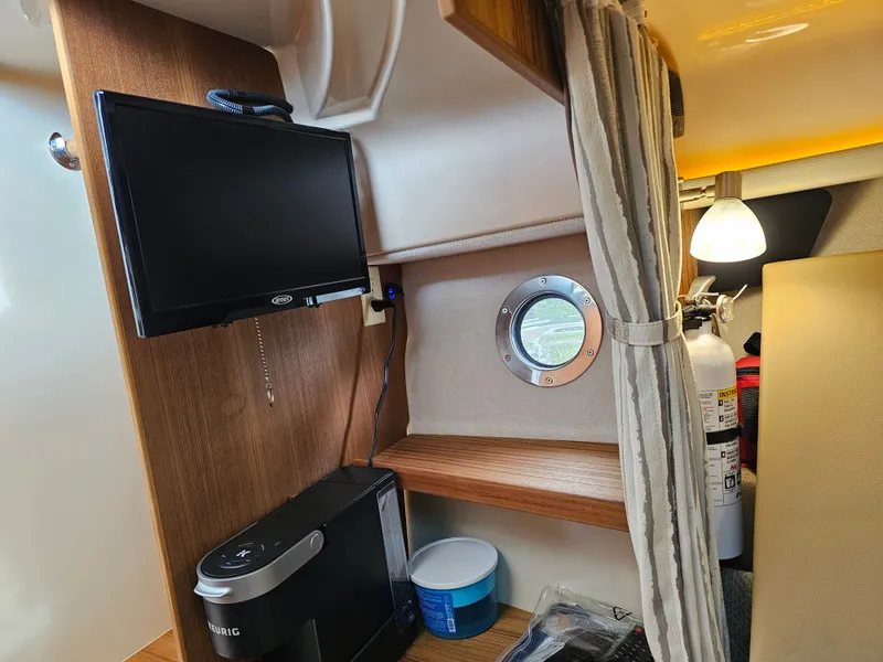 Slide: The Image of Interior of a 2025 Ranger Tugs R-27 with a TV, coffee maker, and fire extinguisher. - 20