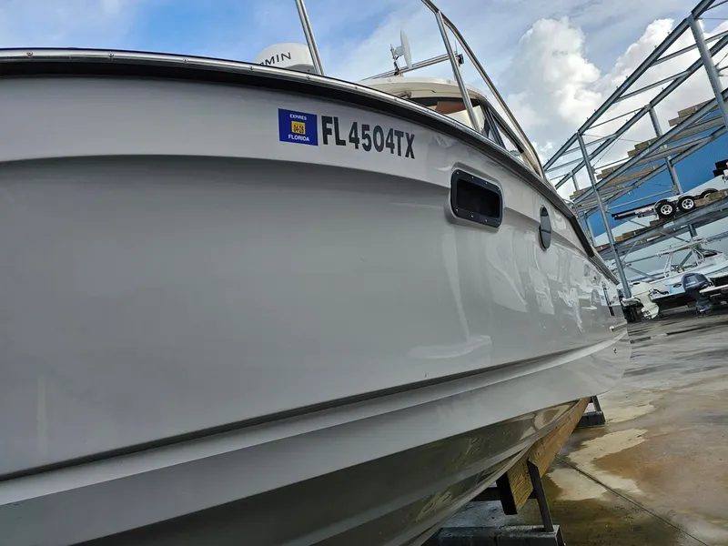 Slide: The Image of Side view of a Ranger Tugs R-27 boat in dry dock, with clear sky in the background. - 39