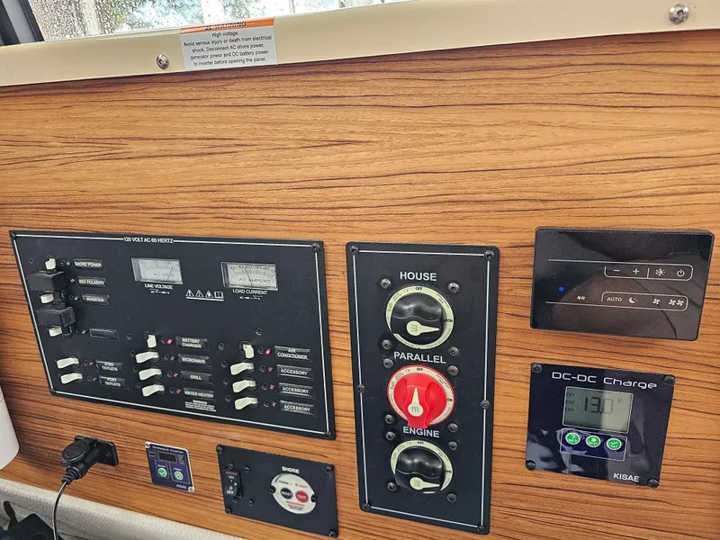 Slide: The Image of The image shows the dashboard of a Ranger Tugs R-27 boat with various switches and gauges. - 31