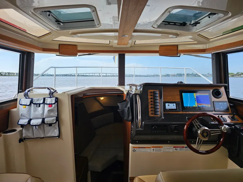 Slide: The Image of The interior of a 2025 Ranger Tugs R-27 features a modern helm with navigation systems. - 15